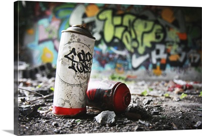 Piece of evidence - empty paint can in front of graffiti-covered wall