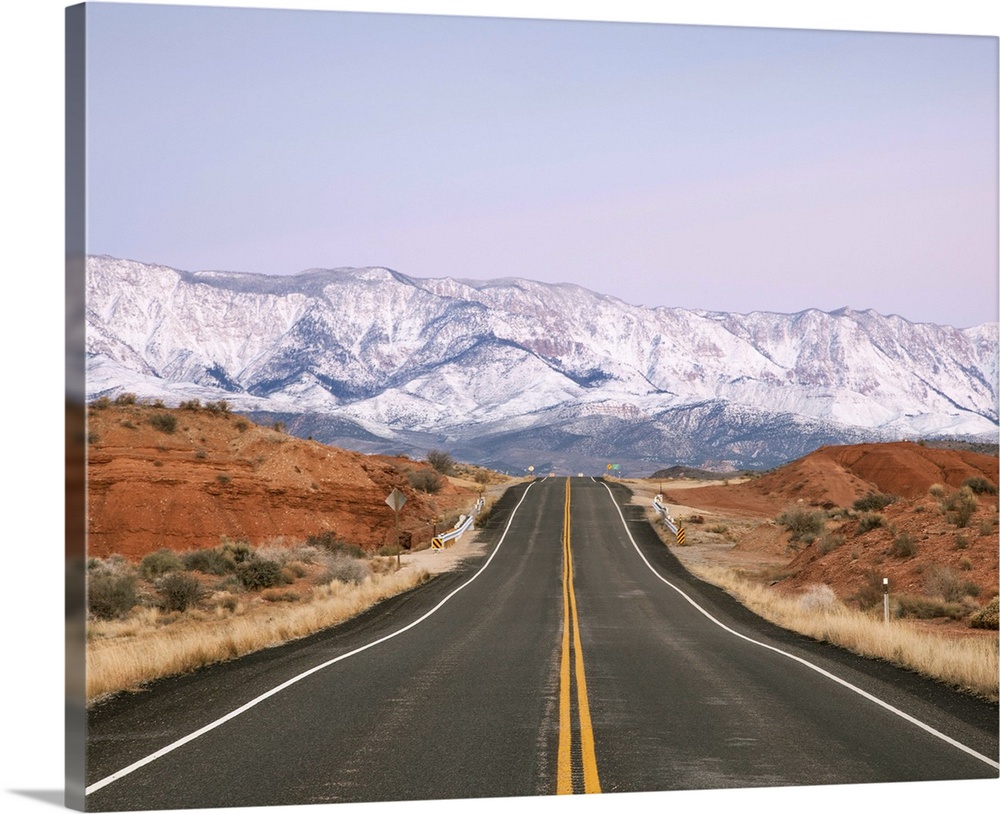 Road leads towards the snow covered Pine Valley Mountains at dawn, near La Verkin, Utah.