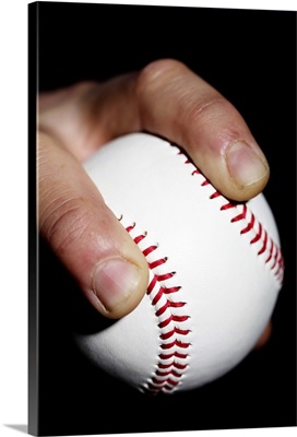 Pitchers hand gripping a baseball