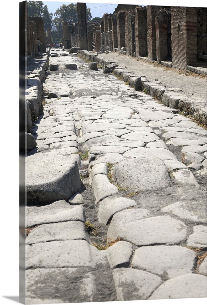 Ruts in the road made by the wheels of Roman carts. Stepping stones and raised foot-ways kept Roman feet out of the mud an...