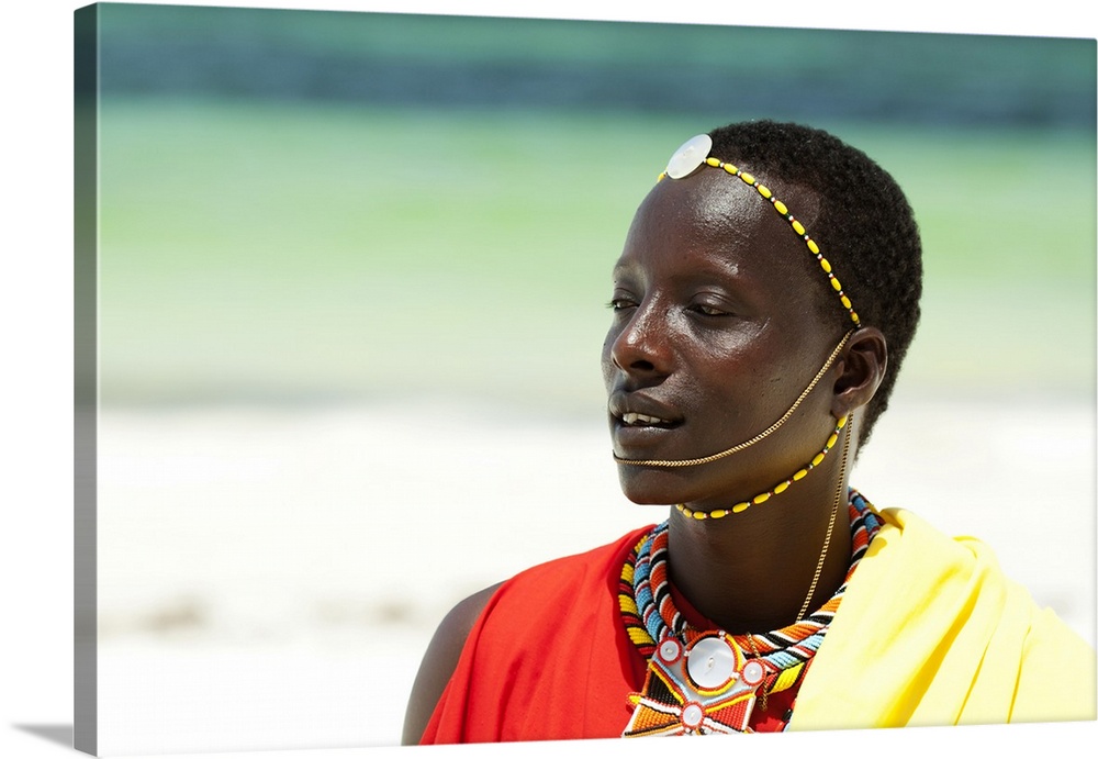 Portrait of young tribal Masai warrior man on hot bright sunny African beach.