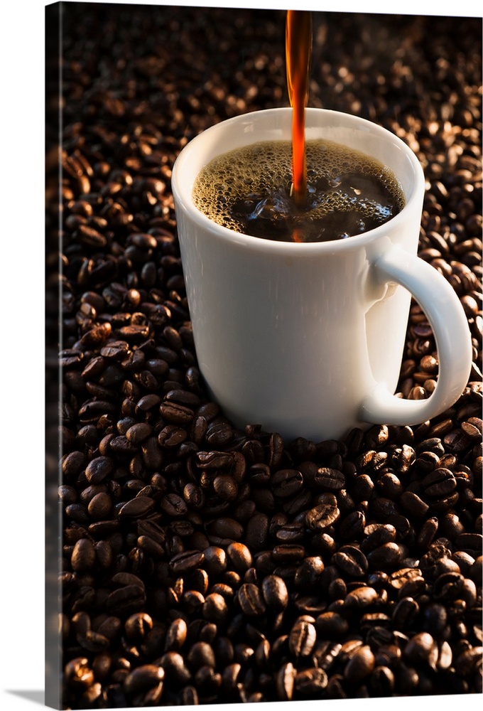 Pouring coffee into cup on coffee beans, studio shot