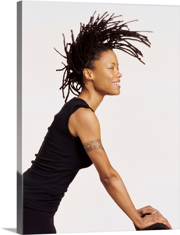 Profile Portrait of a Woman Leaning on a Chair, Tossing Her Dreadlocked Hair and Smiling