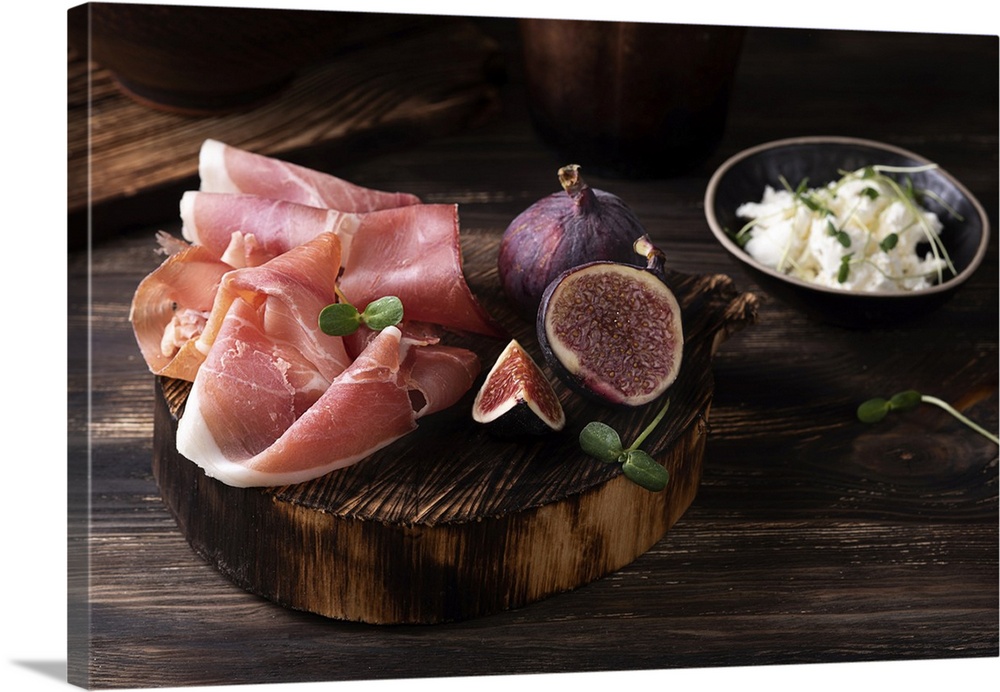 Prosciutto slices with figs on a dark wooden background, appetizer from dry cured ham. Rustic style. Ukraine.