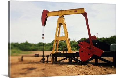 Pump jack pumping oil in field, Venezuela