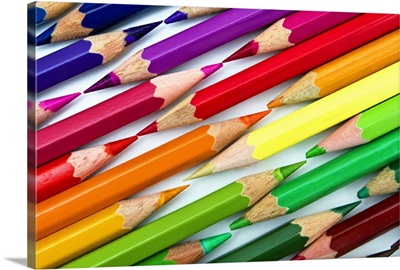Rainbow colored pencils arranged tip to tip.