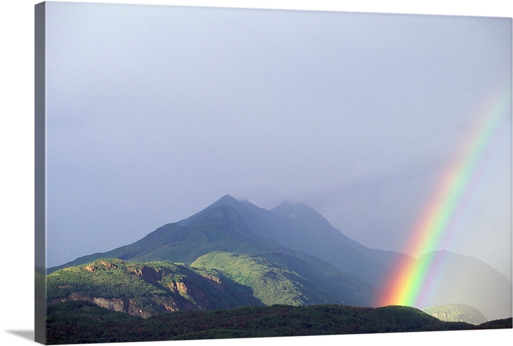 A rainbow forms over the Chugach Mountain Range near the Matanuska Glacier.
