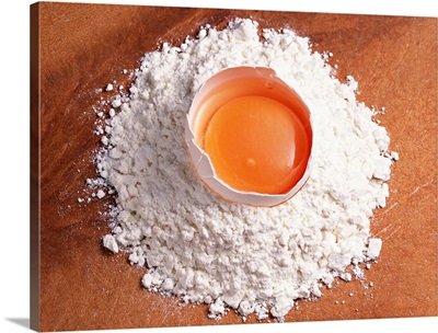 Raw egg sitting on wheat flour