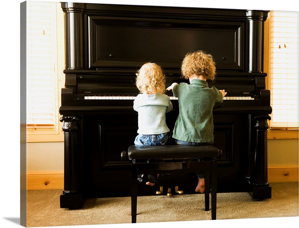 Rear view of two children sitting at upright piano