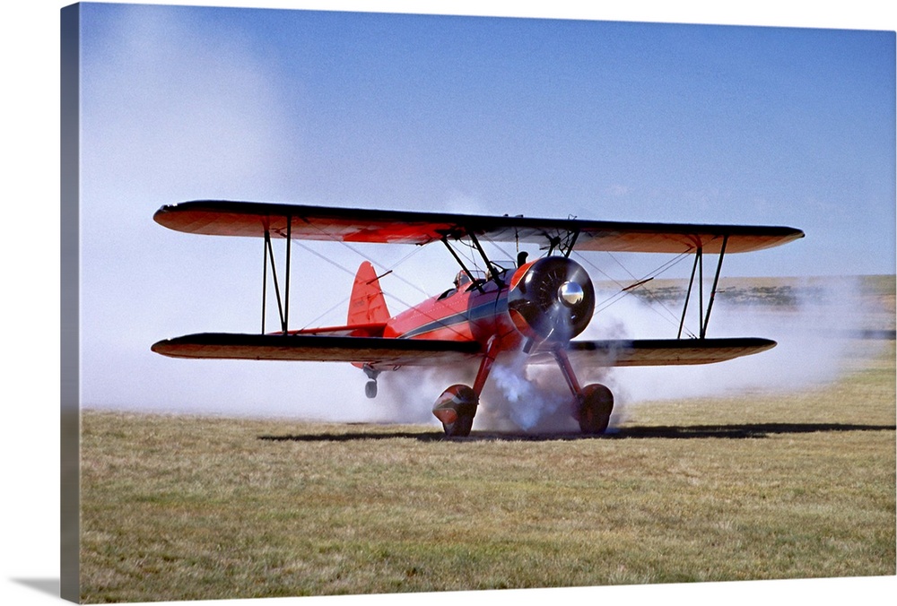 Red Stearman bi-plane taking off with air show smoke