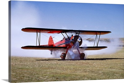 Red Stearman bi-plane taking off with air show smoke