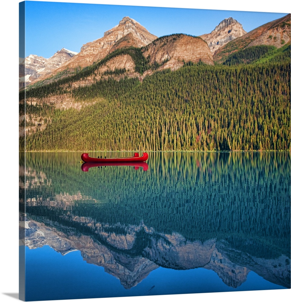 Reflection of mountain and boat in lake Louise, Banff, Alberta.