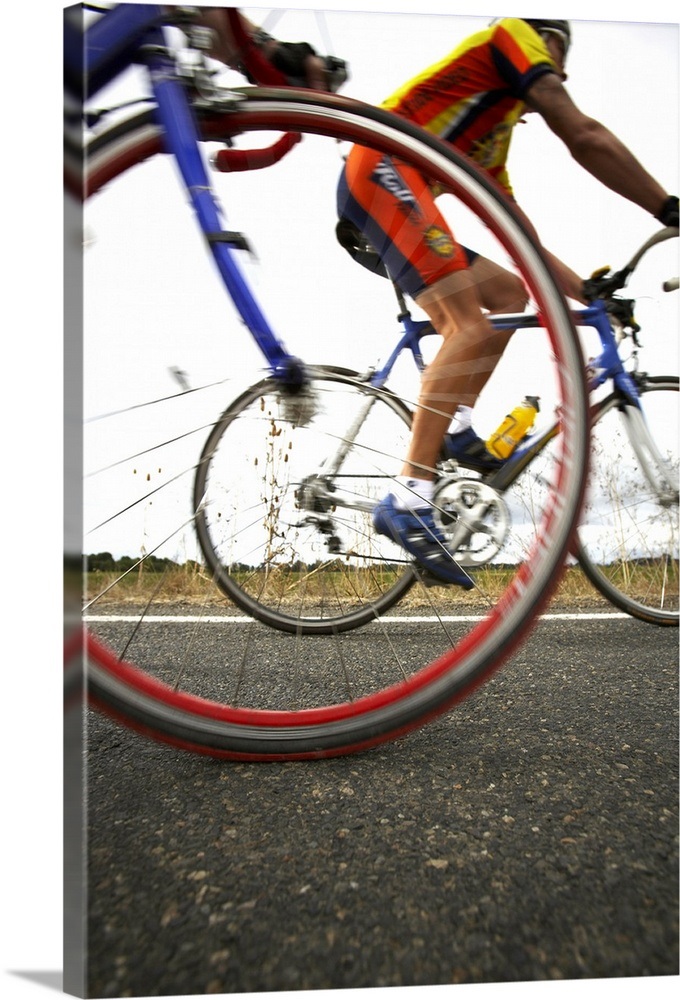 Road cyclist, bicycle wheel in foreground (surface level) Wall Art