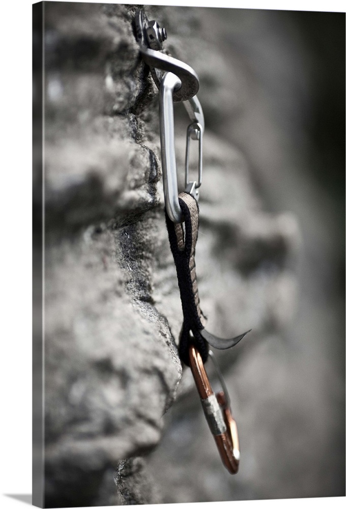 Rock climbing equipment hangs from a rock face.