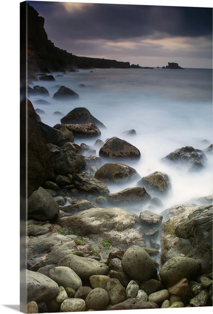 Tranquil scene of sea with small and big rocks near it.