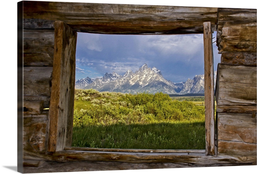 View of Teton mountain range through a cabin window.