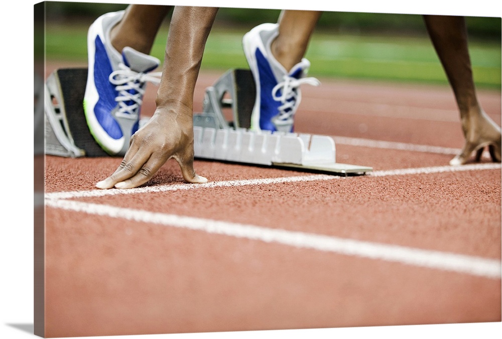 Large photo on canvas of a track athlete at the starting line about to take off sprinting.
