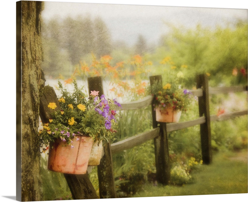 Rustic wooden fence with flowers in clay pots hanging on posts, with Mirror Lake and mountains of Lake Placid,NY in backgr...