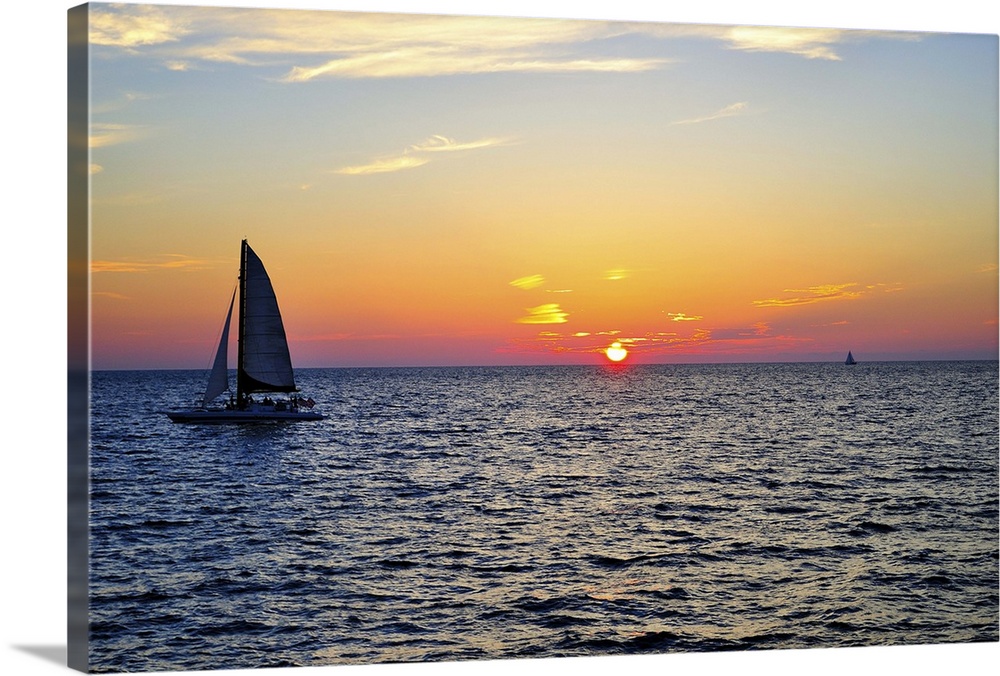 Sail boat on sea at sunset in Gulf of Mexico.