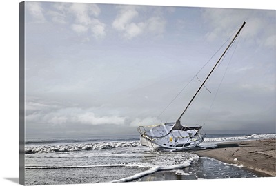 Sailboat grounded on the beach after a storm