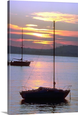 Sailboats in water at sunrise