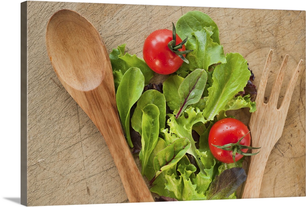 Salad leaves and wooden spoon and fork