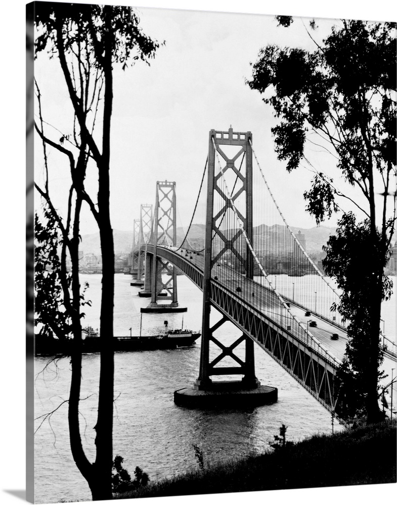 A ship crosses under the San Francisco Oakland Bay Bridge after its completion in 1936. The bridge, designed by Charles H....
