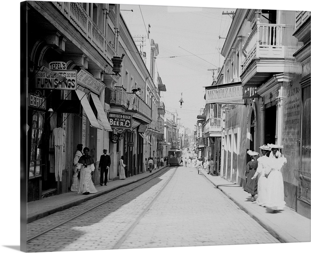 The old narrow colonial San Francisco Street in San Juan, with tracks and a street car running on one side.