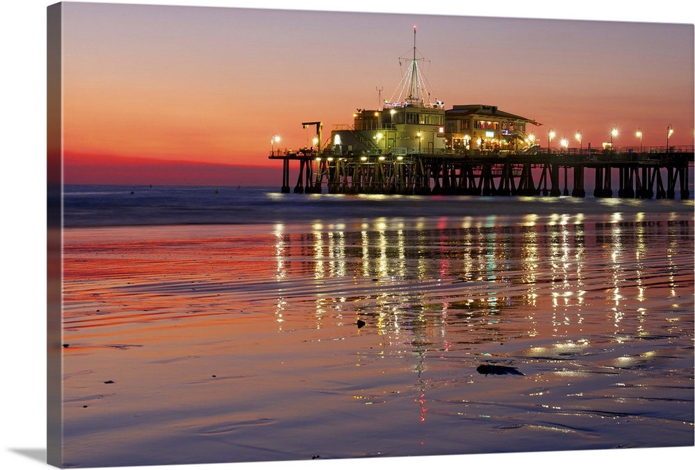 Wet sand reflecting lights of the Santa Monica Pier, just after sunset.