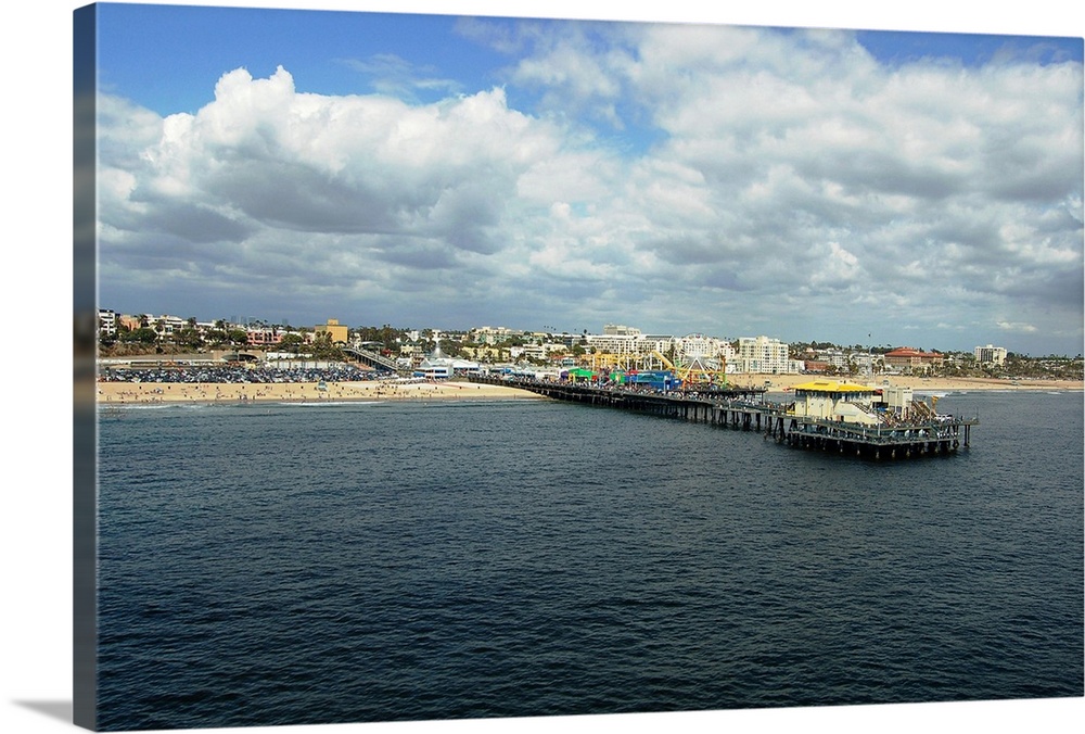 Santa Monica, California, with pier and amusement park, beach and city, under sunny sky with fluffy white clouds, as seen ...