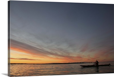 Scenic View of  Man Canoeing Across Bay at Sunset