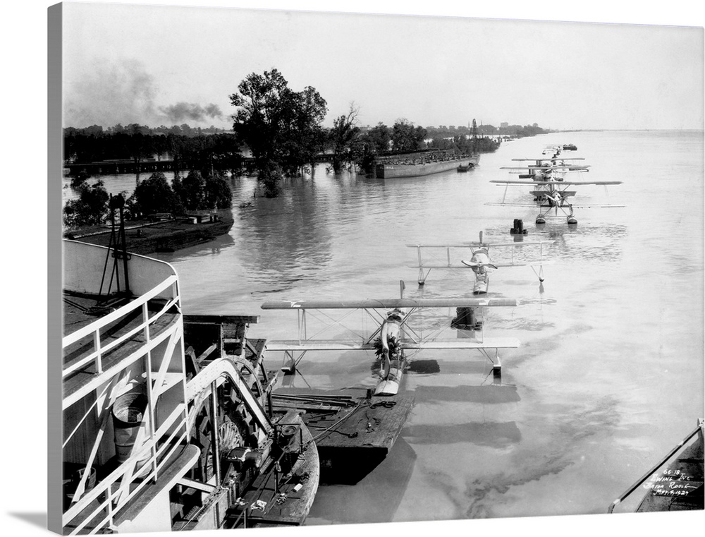 A sternwheeler tows a string of seaplanes down the Mississippi River during a flood. 1927.