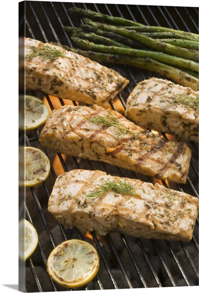 Fish and asparagus cooking on grill