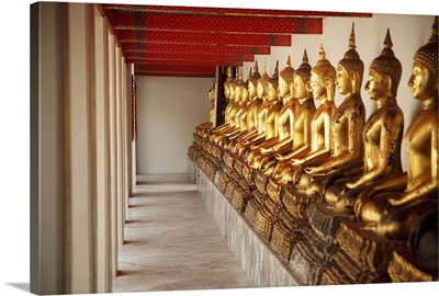 seated golden buddha statues in a row at wat pho, temple of the reclining buddha