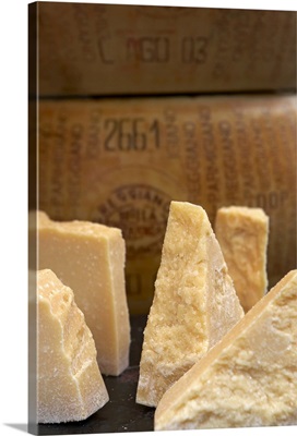 Sections of parmesan cheese on market stall, close-up