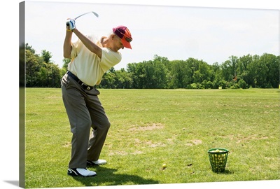 Senior golfer hitting practice balls at a range