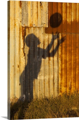 Shadow of a young rugby player throwing a ball