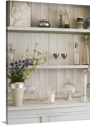 Shelf with flowers and vintage glassware