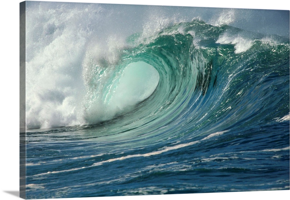 Waves break near the shore in Waimea Bay, one of the few places on earth where waves break in such a way to create ideal c...