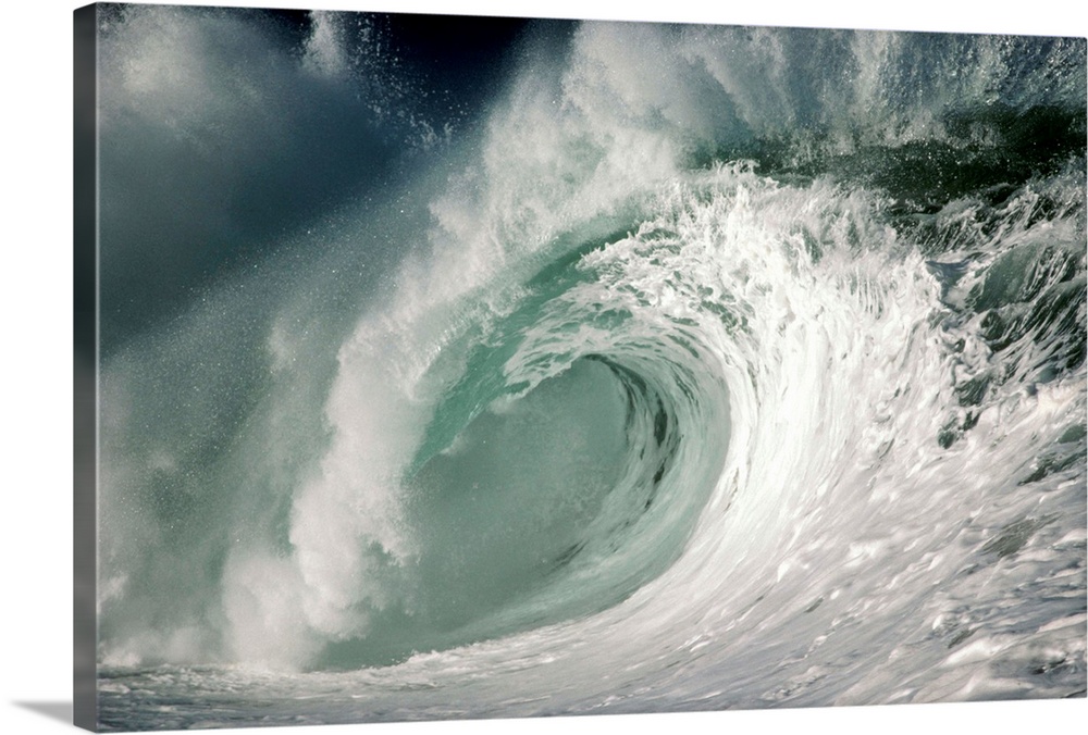 Waves break near the shore in Waimea Bay, one of the few places on earth where waves break in such a way to create ideal c...