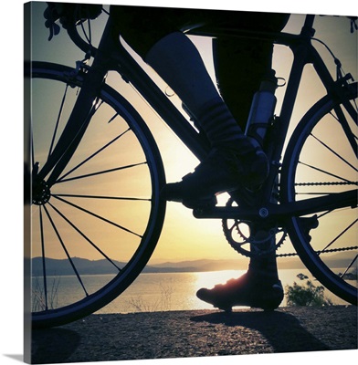 Silhouette of a cyclist and road bike at sunrise