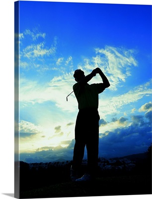 silhouette of a golfer after a swing