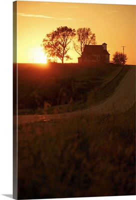 Silhouette of farmhouse at sunset