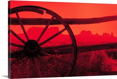 Silhouette of wagon wheel against fence , Utah