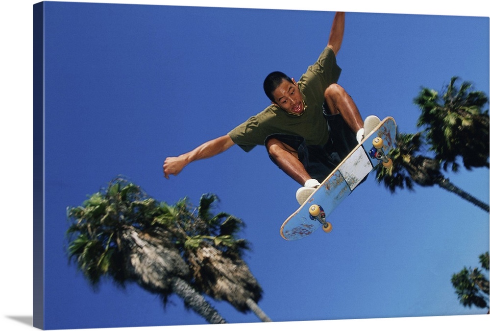 Skateboarder in mid-jump, low angle view