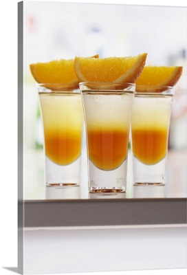 Slices of orange on drinks in shot glasses