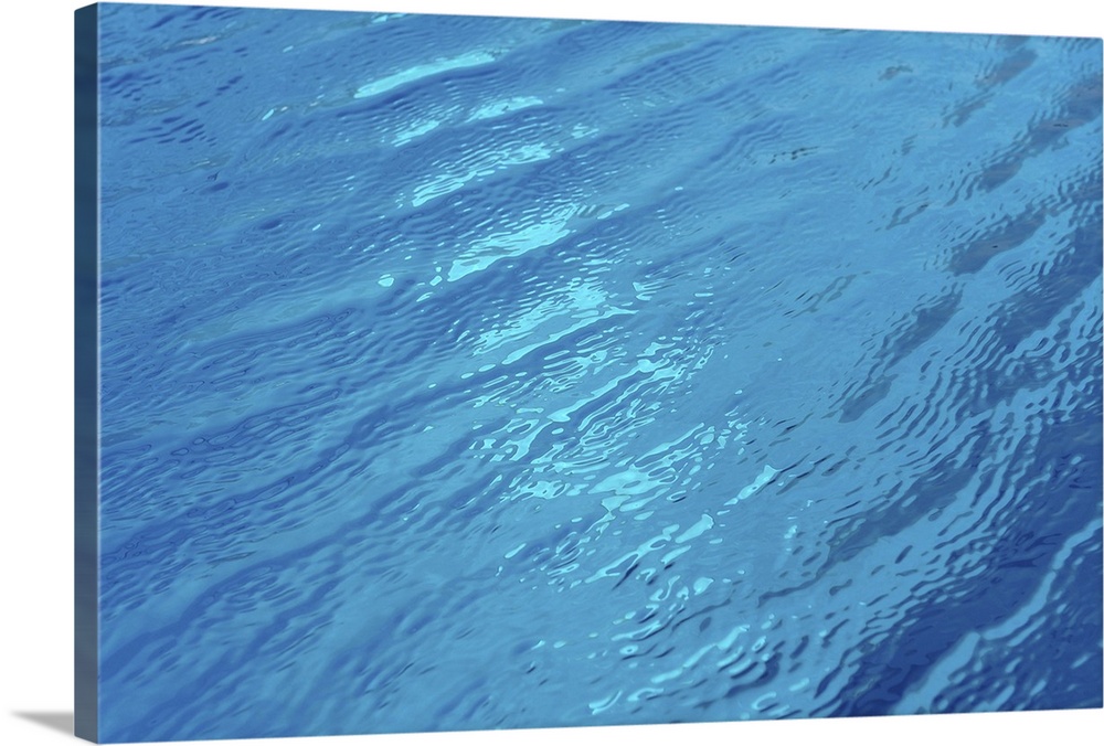 Small waves in blue water of swimming pool.