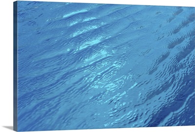 Small waves in blue water of swimming pool.