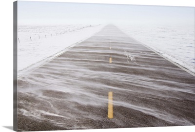 Snow blowing over road