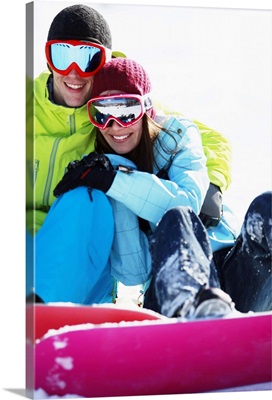 Snowboarder couple sitting on snow